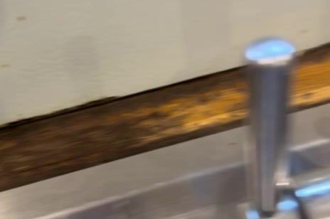 Worn edge of the oak worktop beside the sink