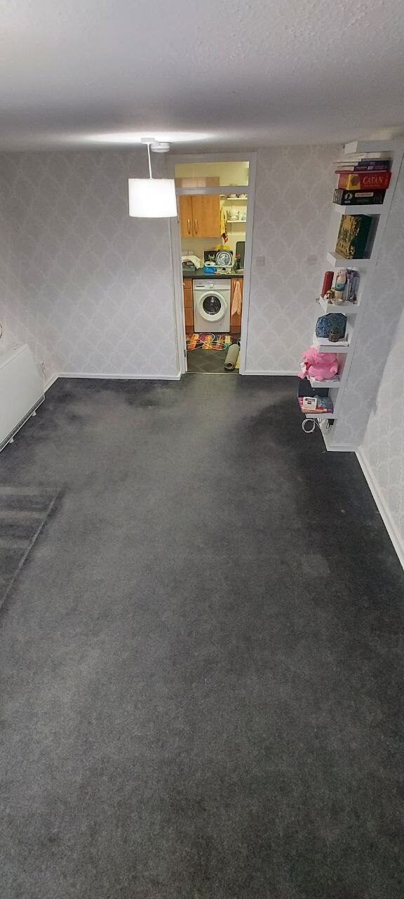 Living room with the old dark carpet, looking towards the kitchen