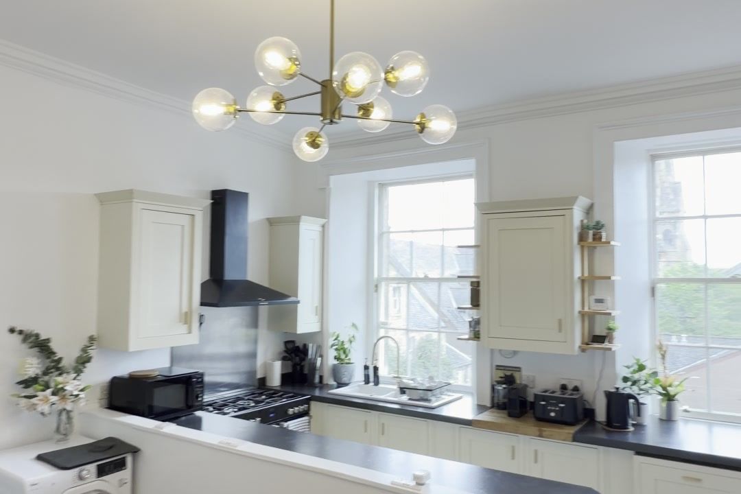 Kitchen with brass pendant light and cream cabinets
